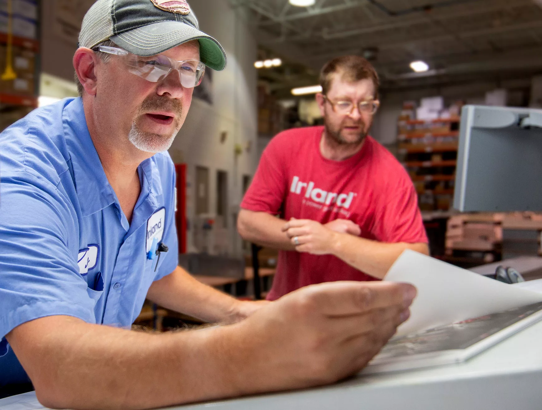 Two Inland employees review a proof before printing labels.