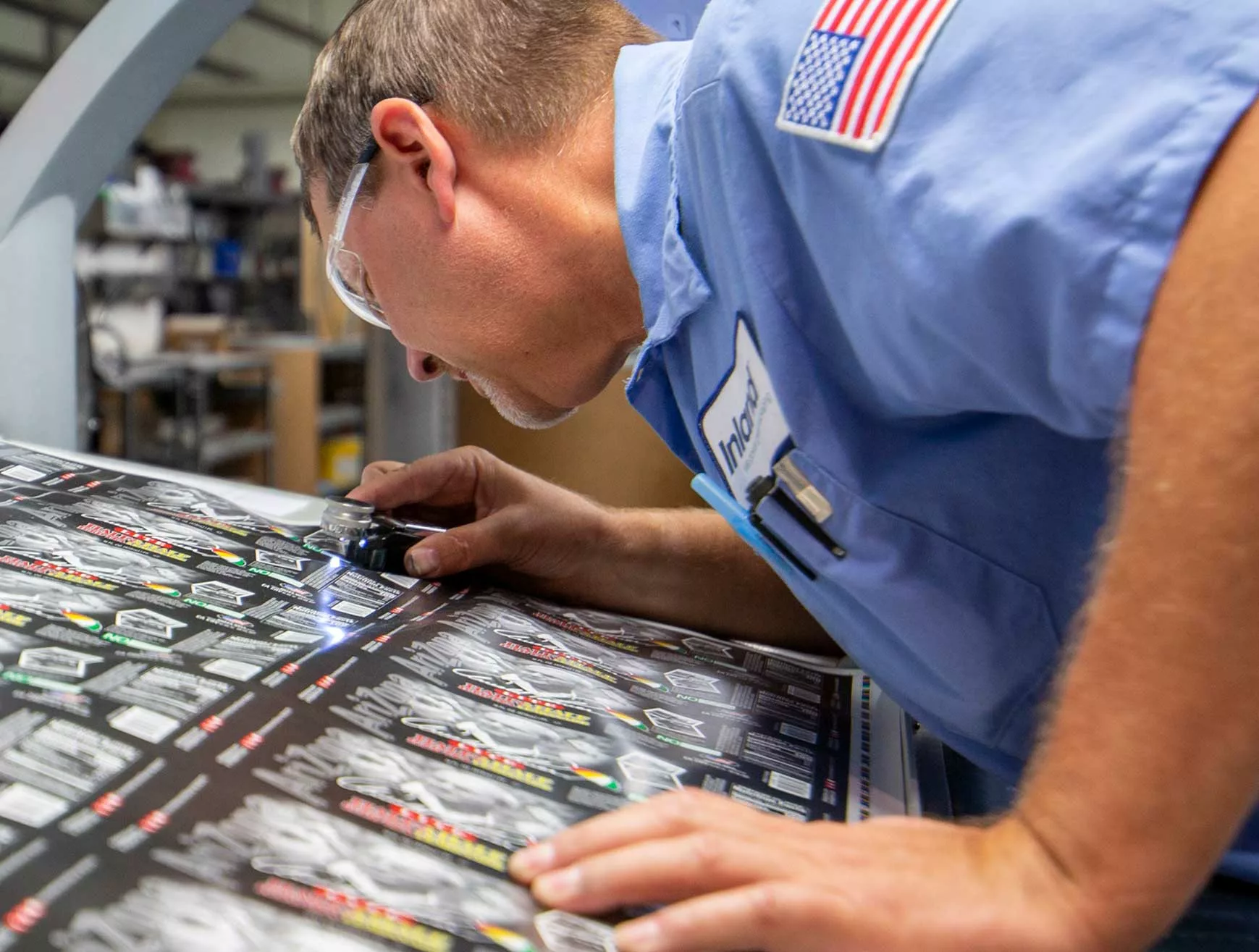 An Inland employee performs quality assurance on a sheet of cut-and-stack labels.