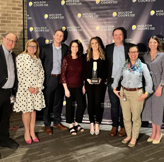 Members of the Inland team posing with a trophy at an awards show.