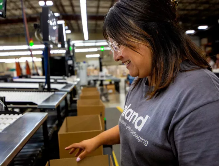 An Inland employee organizes products and boxes to prep them for shipping to clients.